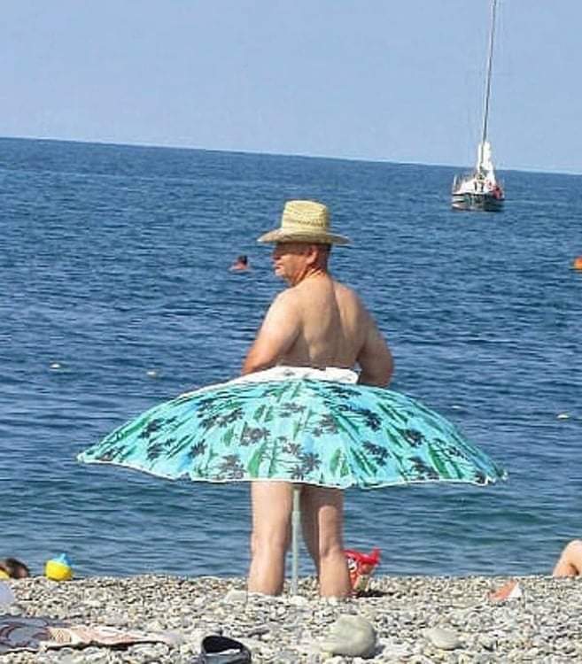 Un homme porte une jupe parasol à la plage.